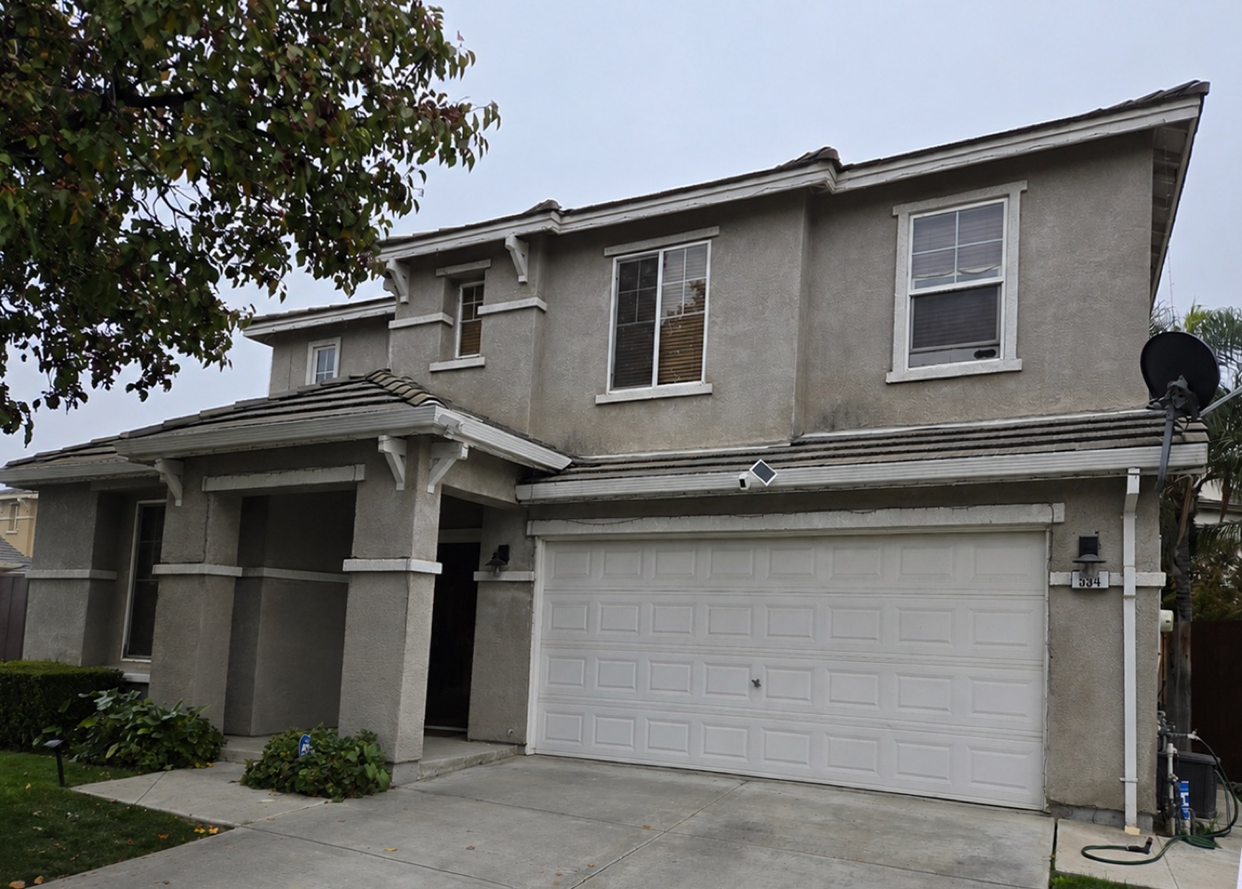 Home exterior before Master Craft Painting, faded and weathered stucco