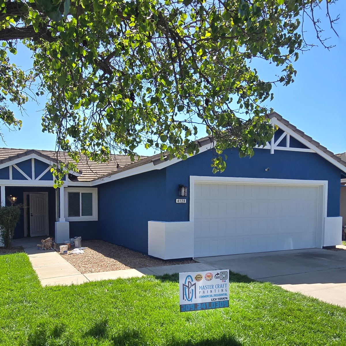 Same home after Master Craft Painting, in deep navy blue with crisp white trim